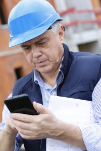 Entrepreneur on construction site using smartphone